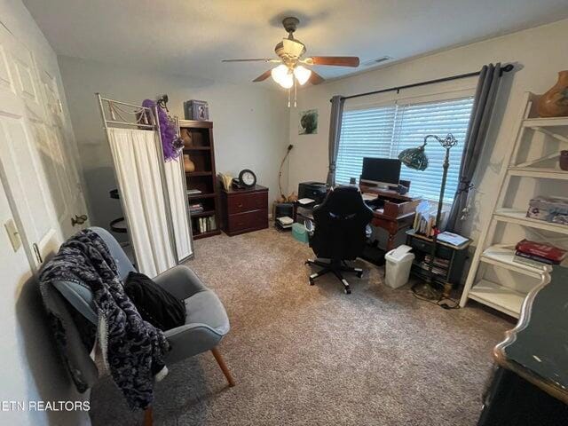 carpeted office featuring ceiling fan