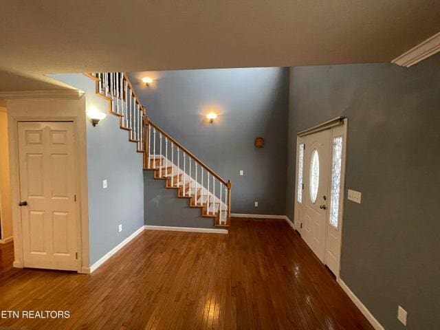 entrance foyer with crown molding and dark hardwood / wood-style flooring