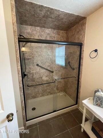 bathroom featuring tile patterned floors and a shower with shower door