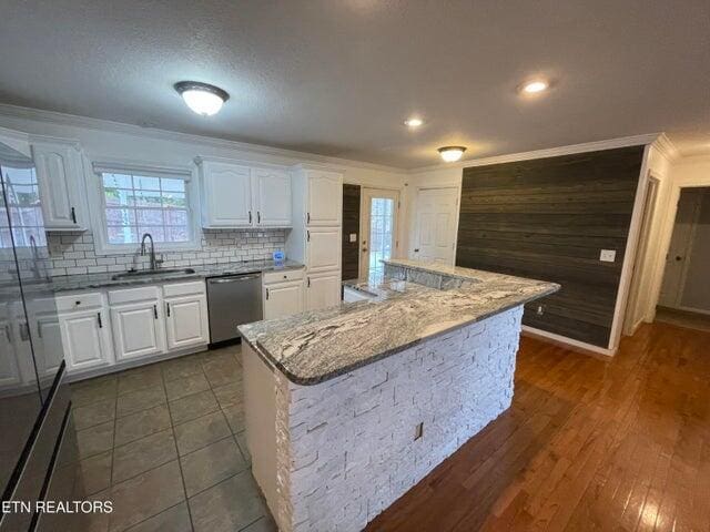 kitchen with white cabinetry, sink, a center island, and stainless steel dishwasher