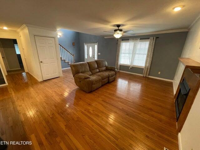 unfurnished living room with ornamental molding, hardwood / wood-style floors, and ceiling fan