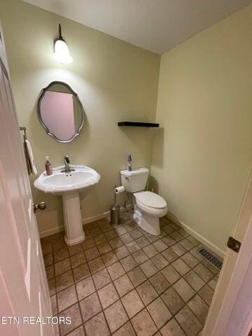 bathroom with toilet and tile patterned flooring