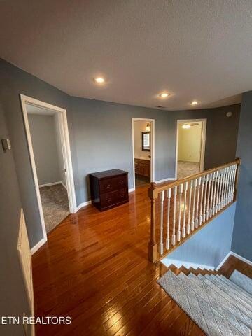 corridor with hardwood / wood-style flooring and a textured ceiling