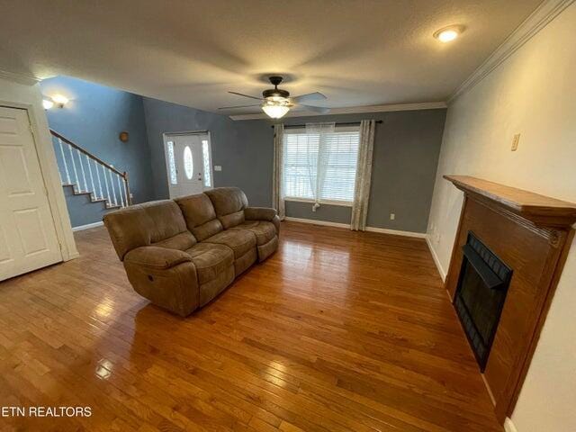 living room with crown molding, ceiling fan, and hardwood / wood-style floors