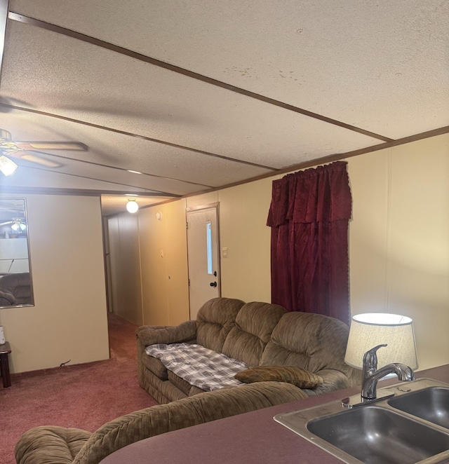 carpeted living room featuring a textured ceiling, ceiling fan, and sink