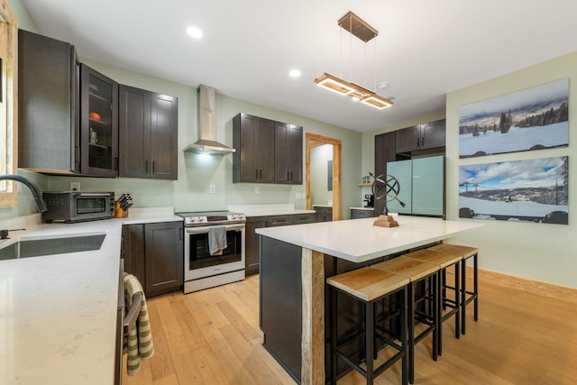120 Hummingbird Way, Copperhill, TN 37317 - kitchen with stainless steel electric range oven, freestanding refrigerator, wall chimney exhaust hood, light wood finished floors, and a kitchen breakfast bar