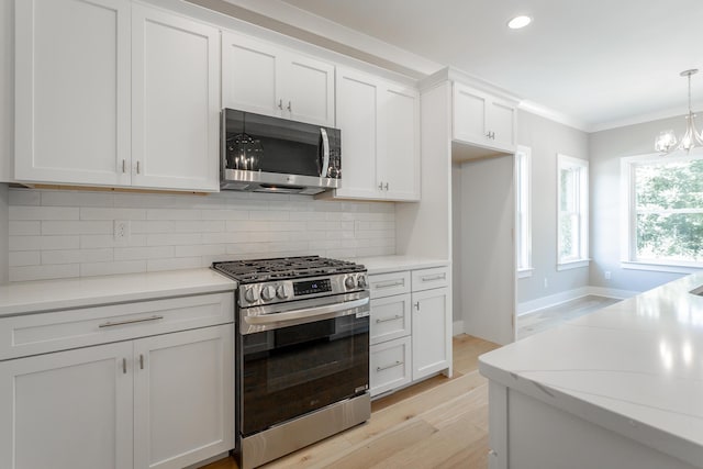 5118 Judd Way NW Unit 21, Cleveland, TN 37312 - kitchen with appliances with stainless steel finishes, light wood-style flooring, white cabinetry, decorative backsplash, and a chandelier