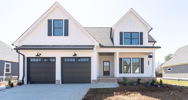 modern inspired farmhouse with driveway, roof with shingles, a standing seam roof, a porch, and board and batten siding