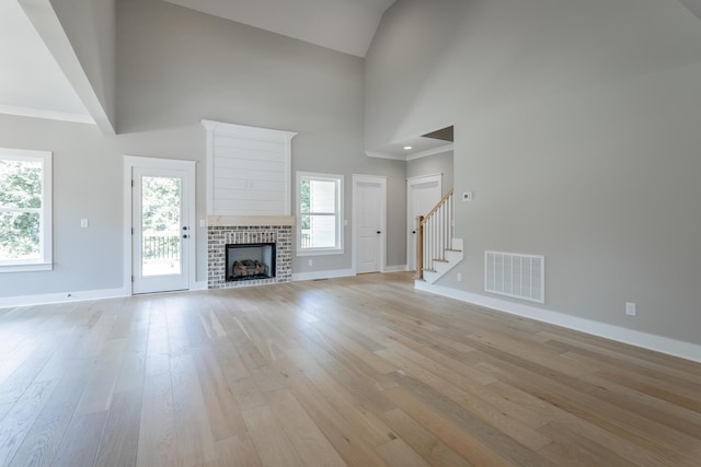 5118 Judd Way NW Unit 21, Cleveland, TN 37312 - unfurnished living room with baseboards, stairway, light wood-style floors, high vaulted ceiling, and a fireplace