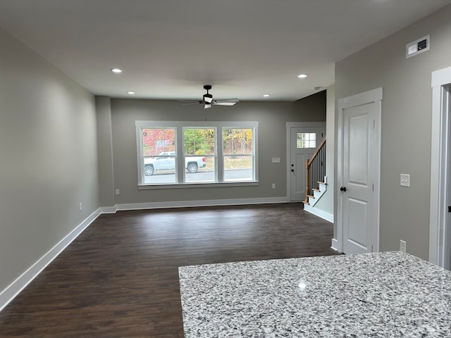 unfurnished living room featuring dark hardwood / wood-style floors and ceiling fan