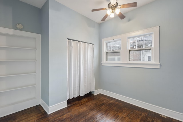 unfurnished bedroom featuring ceiling fan and dark wood-type flooring