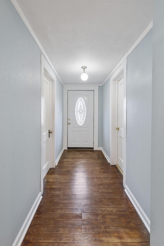 doorway to outside with crown molding and dark hardwood / wood-style floors