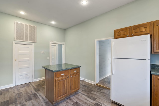 kitchen featuring dark hardwood / wood-style flooring, white refrigerator, and a kitchen island