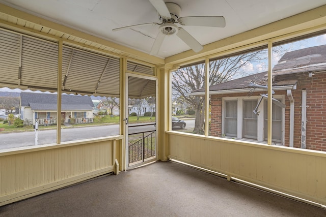 unfurnished sunroom featuring baseboard heating and ceiling fan