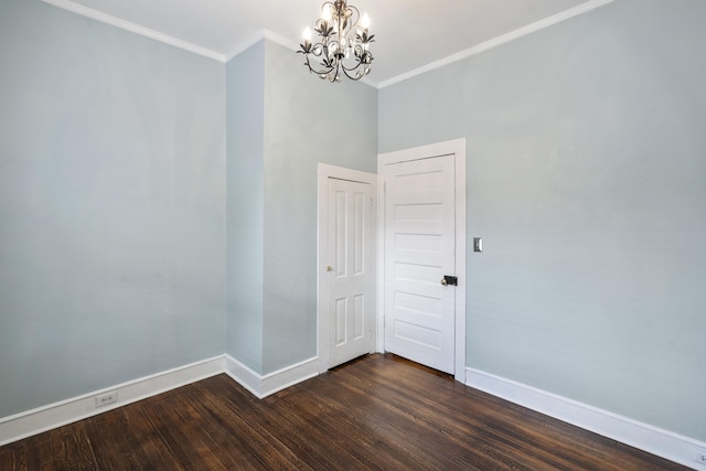 spare room with crown molding, dark hardwood / wood-style floors, and an inviting chandelier