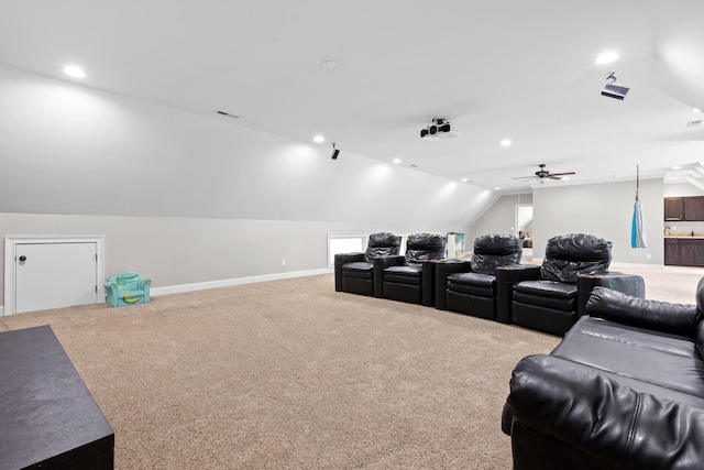 carpeted home theater featuring ceiling fan and vaulted ceiling