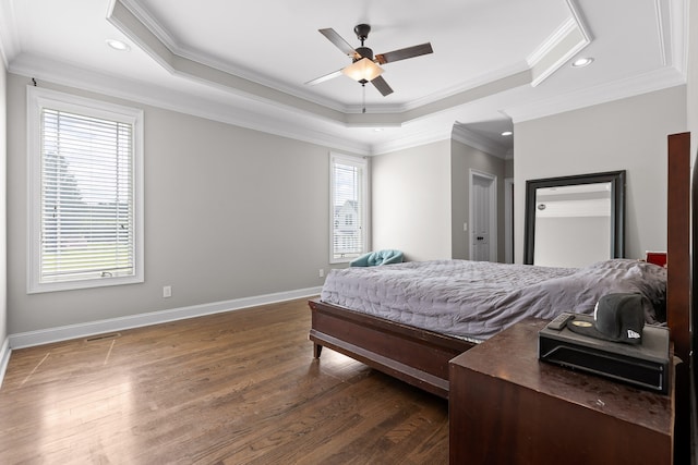 bedroom featuring a raised ceiling, ceiling fan, dark hardwood / wood-style flooring, and ornamental molding