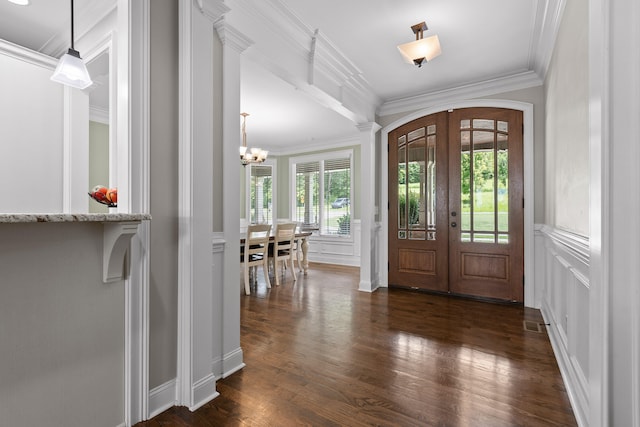 foyer featuring a chandelier, dark hardwood / wood-style flooring, ornamental molding, and french doors