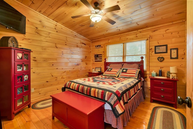 bedroom with ceiling fan, wood walls, wooden ceiling, and light hardwood / wood-style flooring