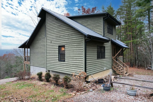 view of home's exterior featuring log veneer siding and metal roof