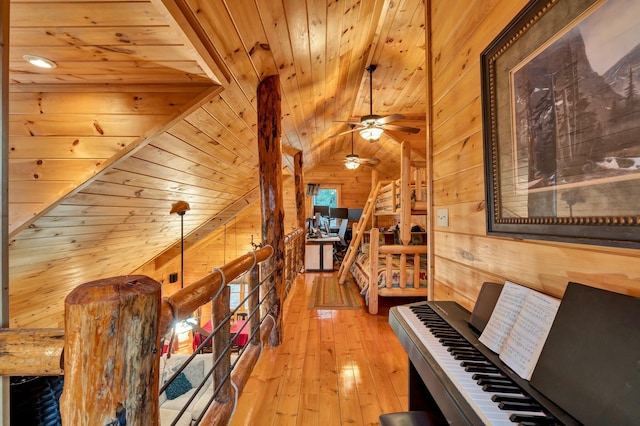 interior space with light hardwood / wood-style floors, vaulted ceiling, wooden walls, and wood ceiling