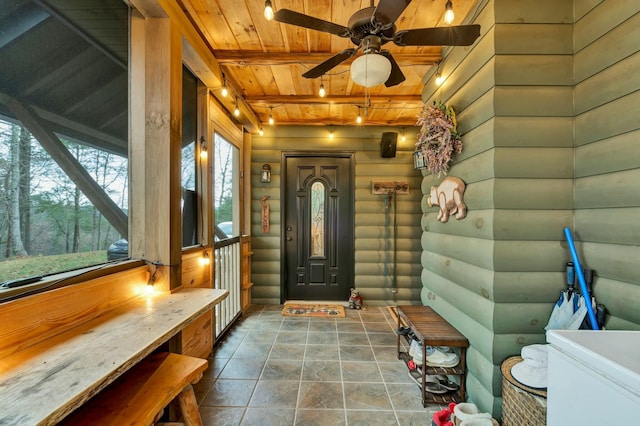 interior space featuring log walls, beamed ceiling, ceiling fan, and wooden ceiling