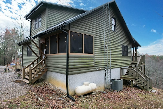 view of side of property with central air condition unit and a sunroom