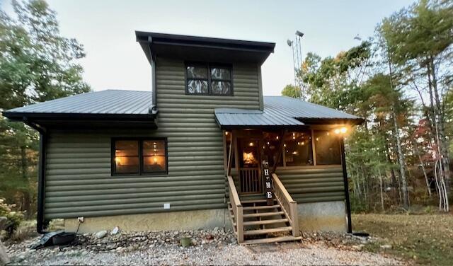 view of front of property featuring a sunroom and metal roof