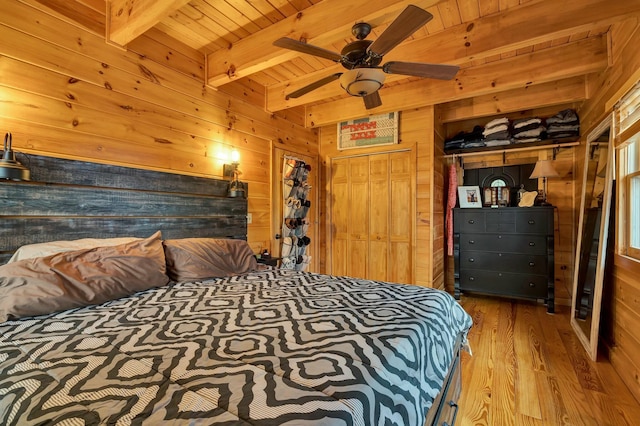 bedroom featuring beam ceiling, wood ceiling, and wooden walls