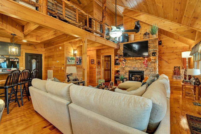 living room featuring wooden walls, a fireplace, wooden ceiling, and light wood-type flooring