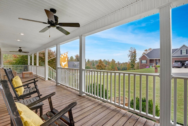 wooden deck featuring a lawn, ceiling fan, and covered porch