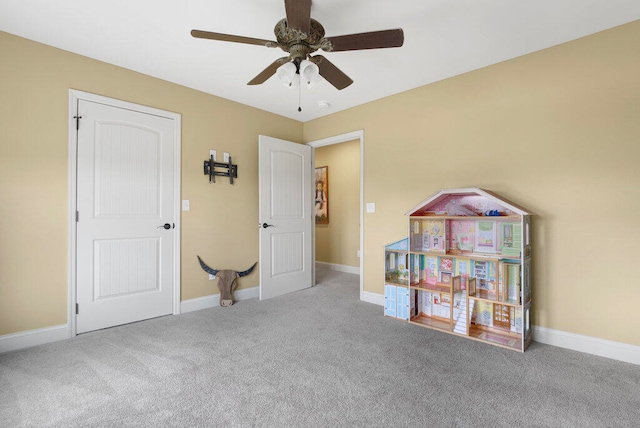 game room with ceiling fan and light colored carpet