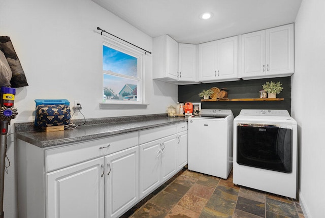 laundry area with separate washer and dryer and cabinets