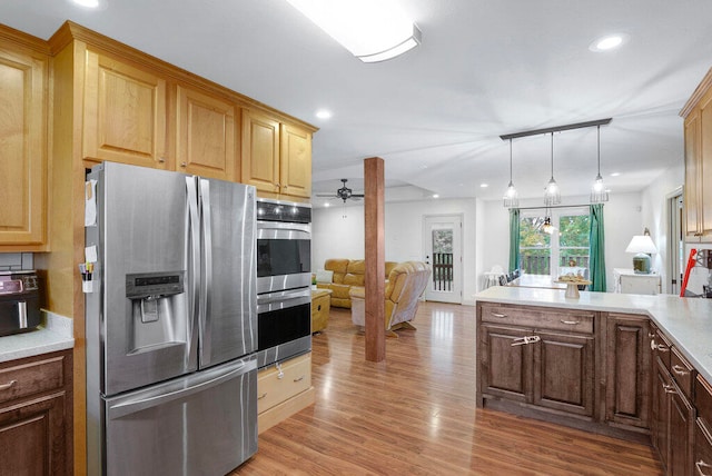 kitchen with ceiling fan, light hardwood / wood-style floors, stainless steel appliances, and hanging light fixtures