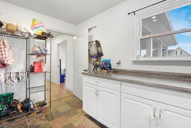 bar with white cabinetry and dark wood-type flooring