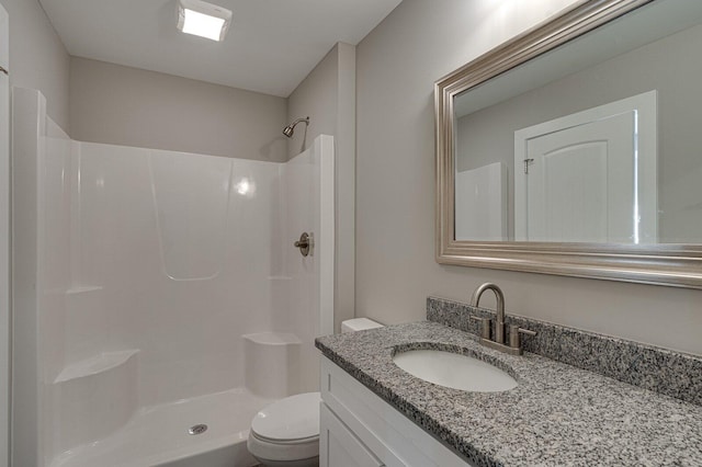 bathroom featuring vanity, toilet, and a shower