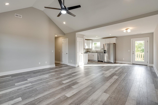 unfurnished living room featuring ceiling fan, light hardwood / wood-style flooring, and high vaulted ceiling