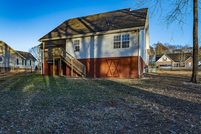 back of property with a lawn, stairs, and fence