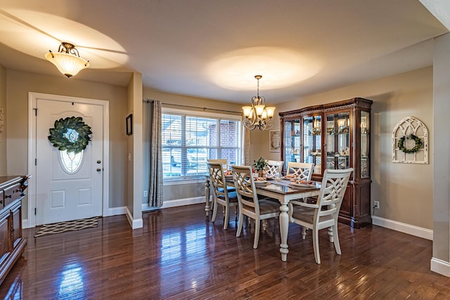 dining area featuring baseboards, a notable chandelier, and dark wood finished floors