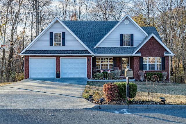 traditional-style house with brick siding, covered porch, concrete driveway, and a shingled roof