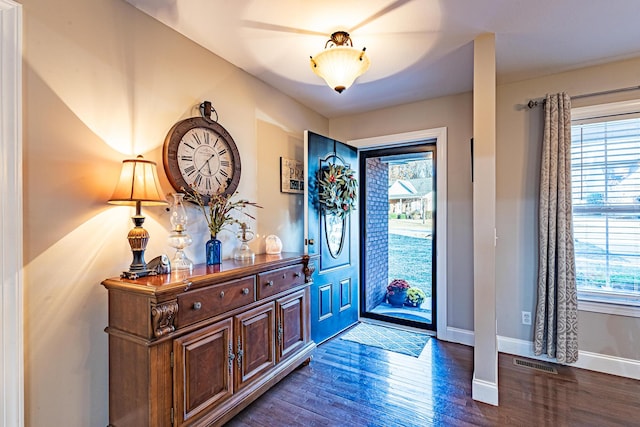 foyer with wood finished floors, visible vents, and baseboards