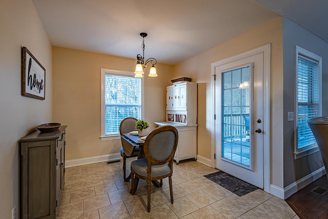 dining area featuring a notable chandelier, visible vents, and baseboards