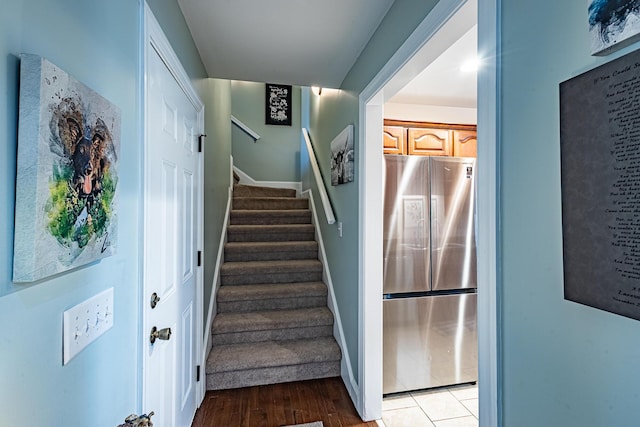 staircase featuring baseboards and wood finished floors