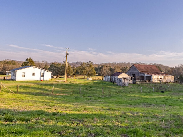 view of yard with an outbuilding and a rural view