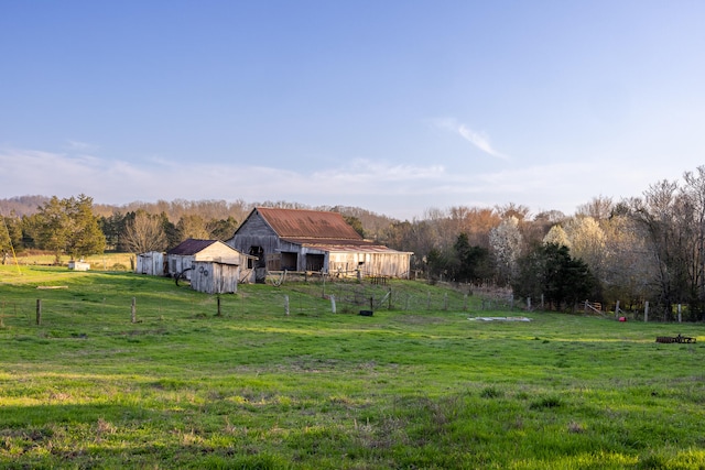 view of yard with a rural view and an outdoor structure