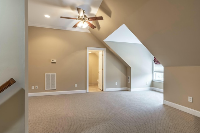 additional living space with light colored carpet, vaulted ceiling, and ceiling fan