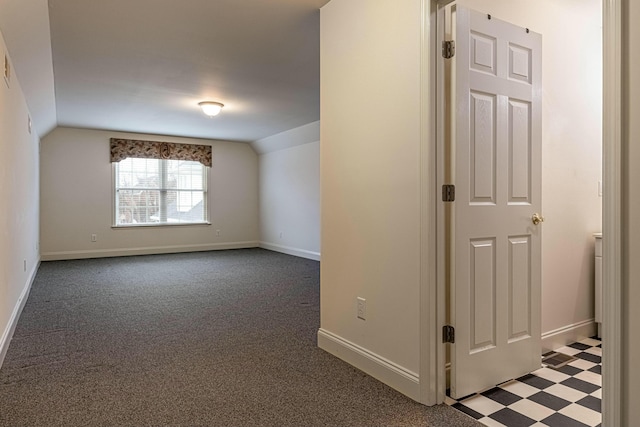 additional living space with dark carpet and lofted ceiling