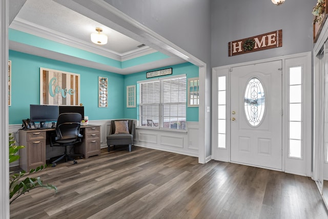 entrance foyer with hardwood / wood-style flooring, crown molding, and a raised ceiling