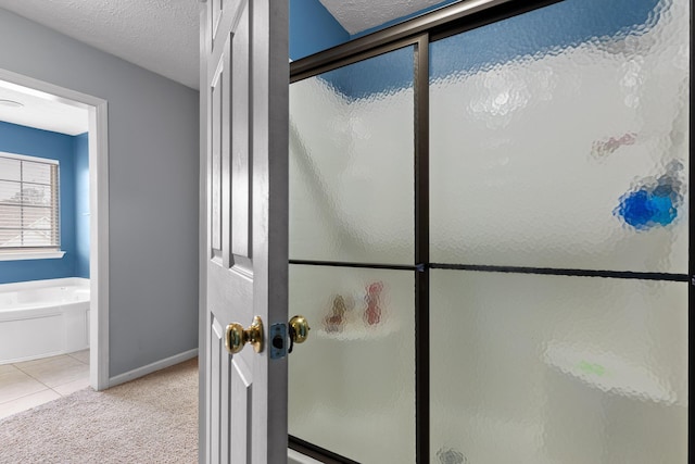 bathroom featuring independent shower and bath, tile patterned flooring, and a textured ceiling