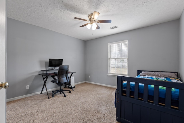 carpeted bedroom featuring ceiling fan and a textured ceiling